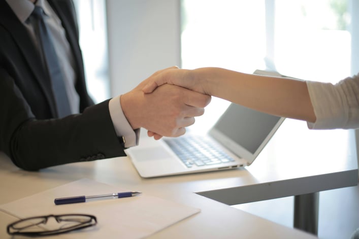 Two people shaking hands to signify successful risk management planning