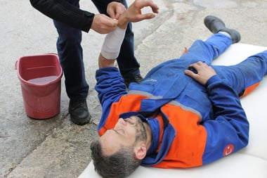 Worker receiving hand treatment after an on-the-job incident, following incident management process.