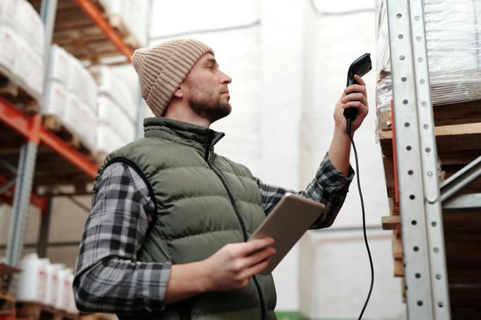 Warehouse worker scanning inventory, part of daily fleet risk assessment routines