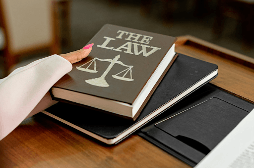 A person holding a law book emphasizing legal and regulatory compliance in health care