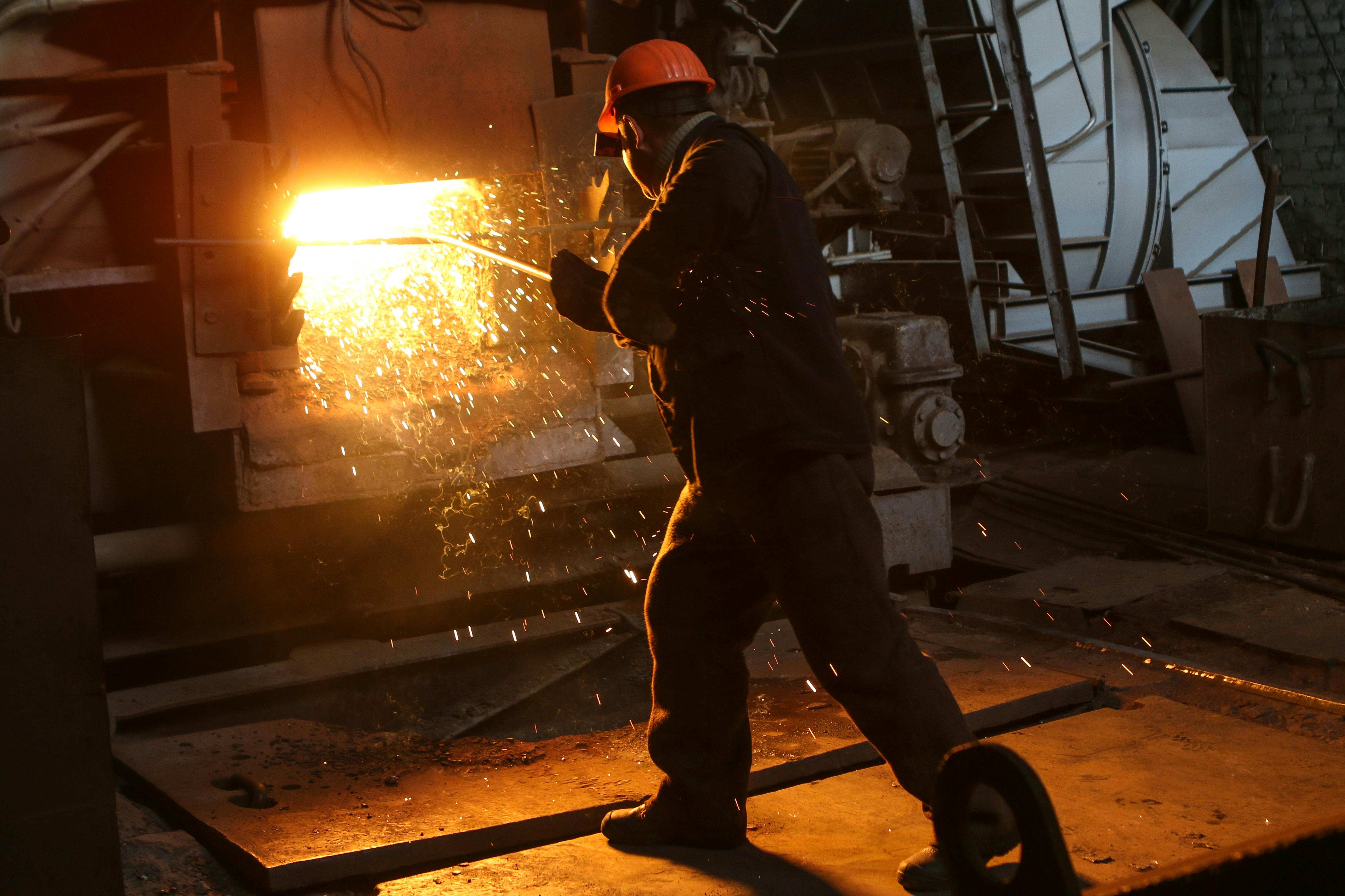 man in helmet working near furnace