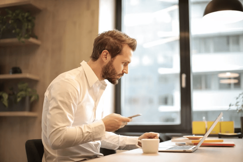 Professional evaluating governance risk management and compliance applications on laptop