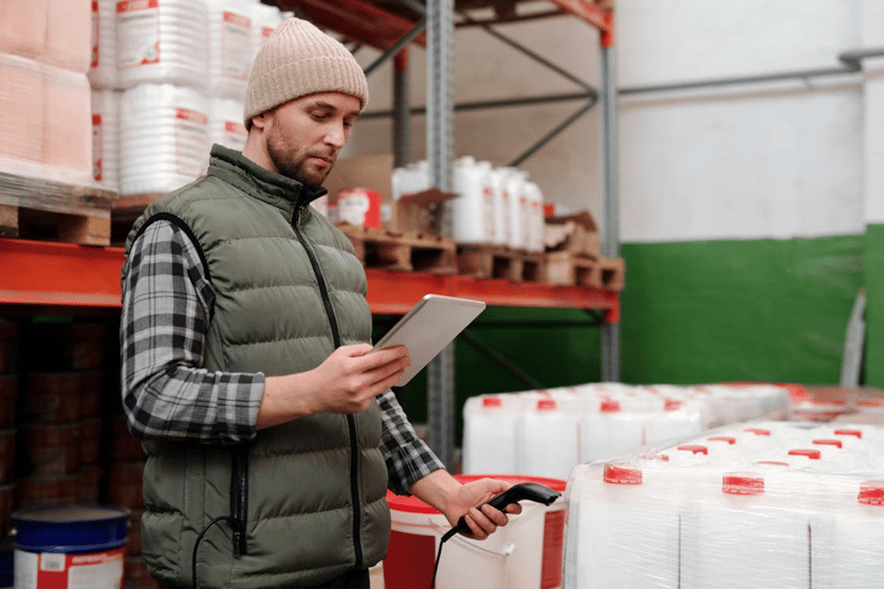 Worker using tablet for supply chain incident management in warehouse
