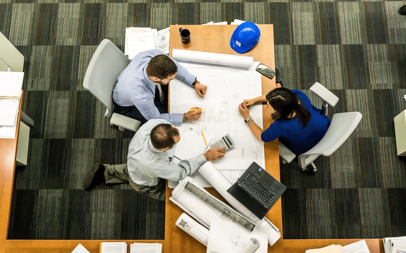 Team reviewing construction plans for claim management solutions and compliance
