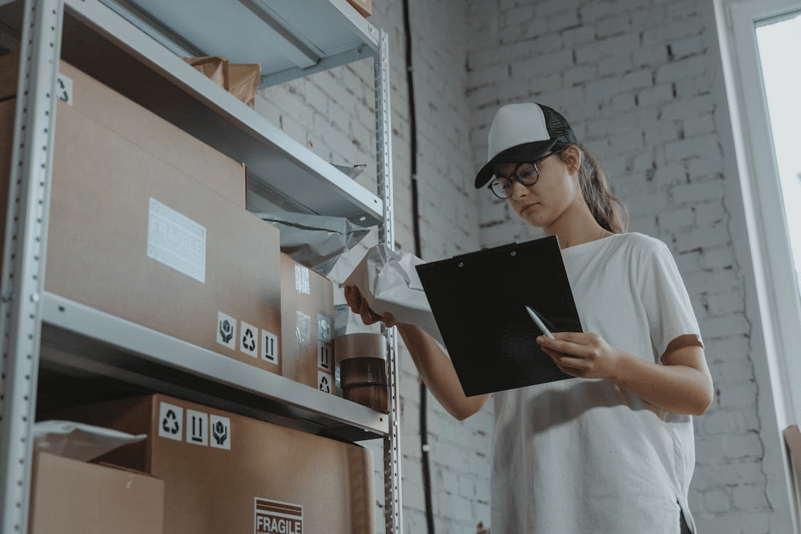 Worker documenting packages with clipboard for workers compensation software reporting and compliance