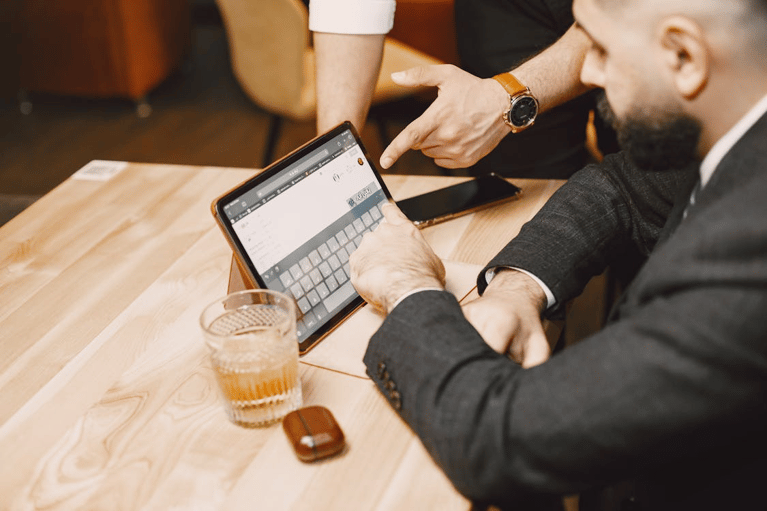 Professionals collaborating on a tablet, illustrating digital claims management system workflows.
