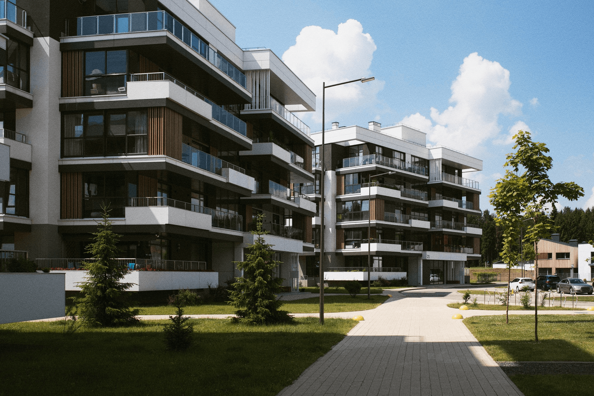 Modern apartment buildings with glass balconies and landscaped surroundings, representing the importance of real estate risk management